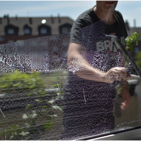 ein Gebäudereiniger, der ein Schaufenster von innen putzt